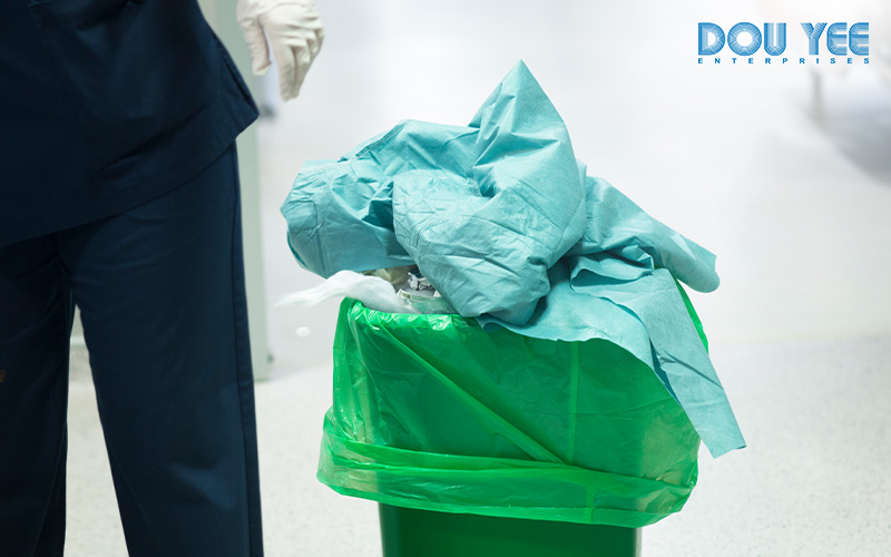 Used PPE being disposed of in a green bin.